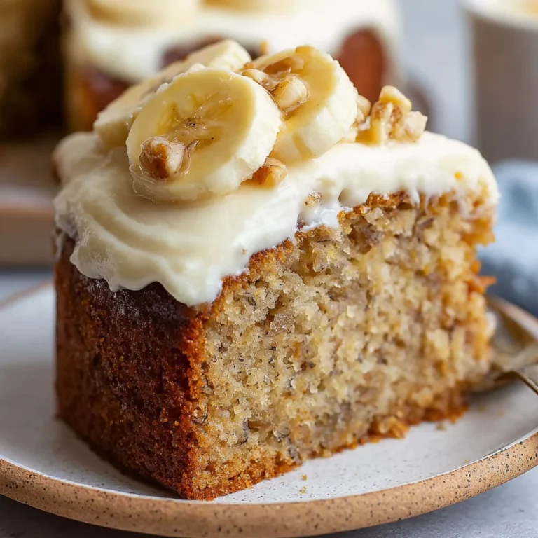 the moistest banana cake with thick cream cheese frosting sliced on a white cake stand showing tender golden crumb